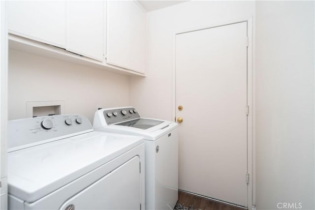 washroom featuring washer and dryer, cabinet space, and wood finished floors