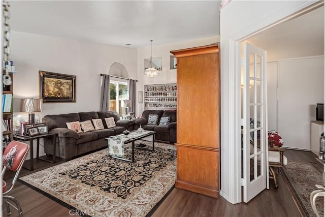 living area with dark wood finished floors and a notable chandelier