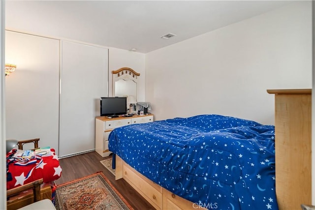 bedroom featuring wood finished floors and visible vents