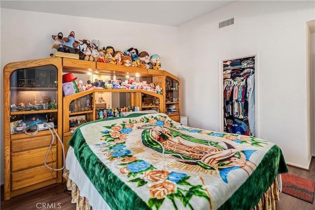 bedroom with visible vents, a closet, and wood finished floors