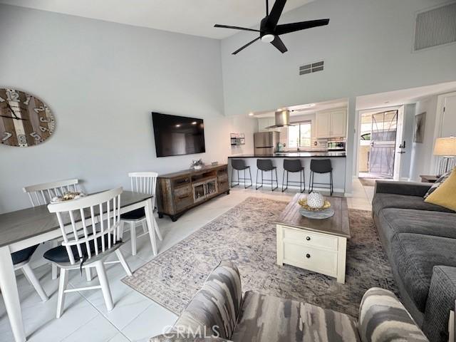 living room with visible vents, high vaulted ceiling, and a ceiling fan