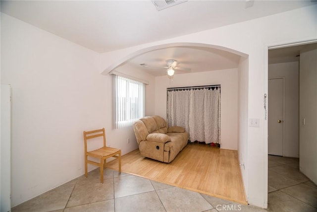 unfurnished room featuring arched walkways, tile patterned flooring, visible vents, and ceiling fan