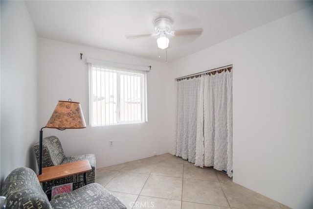 sitting room featuring tile patterned floors and ceiling fan