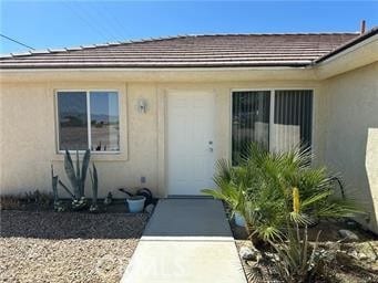 entrance to property featuring stucco siding