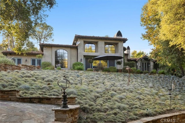 view of front of property with a tiled roof, french doors, and stucco siding