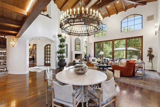 dining room featuring visible vents, arched walkways, wood ceiling, and wood finished floors