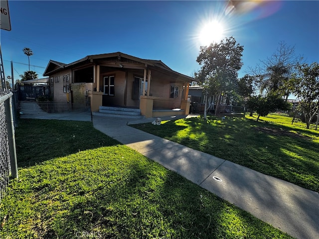 view of front of property with covered porch, a front yard, and fence