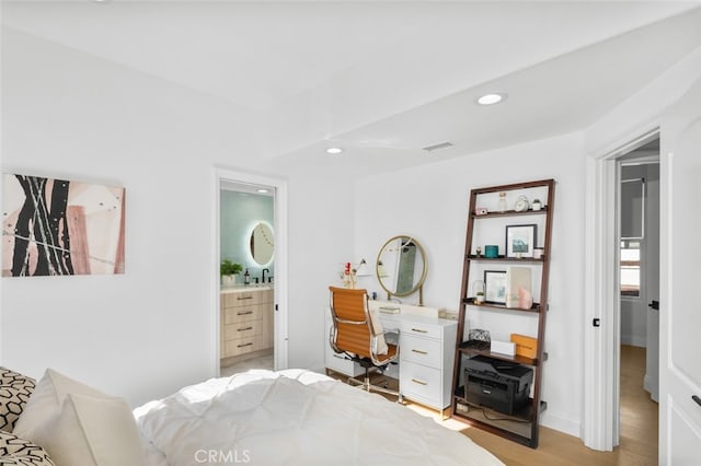 bedroom featuring visible vents, baseboards, recessed lighting, ensuite bathroom, and light wood-style floors