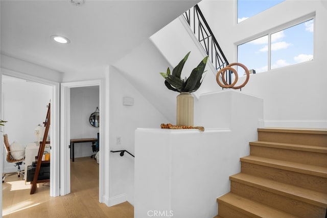 staircase with recessed lighting and wood finished floors