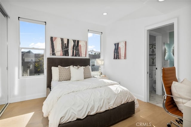 bedroom featuring recessed lighting, ensuite bath, baseboards, and wood finished floors