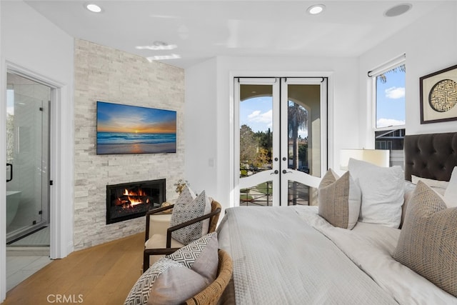 bedroom featuring access to exterior, multiple windows, french doors, and wood finished floors