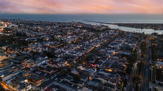 aerial view at dusk featuring a water view