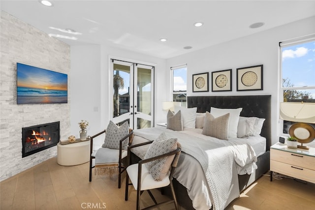 bedroom featuring multiple windows, wood-type flooring, and access to exterior