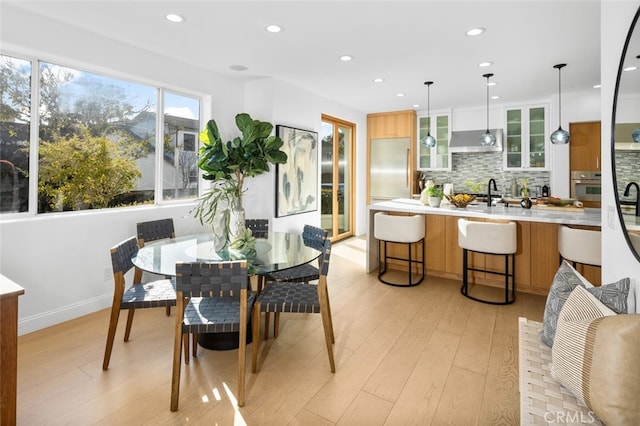 dining space featuring recessed lighting, baseboards, and light wood-style flooring