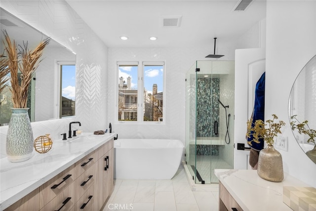 full bath with visible vents, recessed lighting, a shower stall, a freestanding bath, and vanity