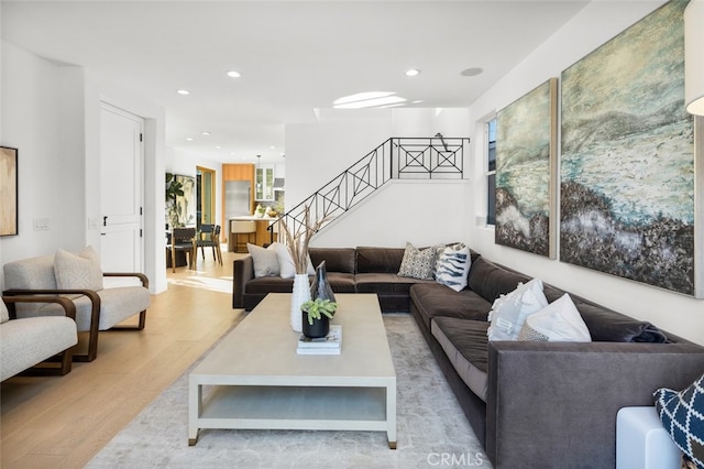 living area with recessed lighting, stairs, and wood finished floors