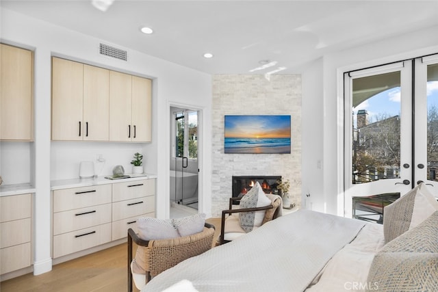 bedroom featuring light wood finished floors, visible vents, recessed lighting, a fireplace, and access to outside