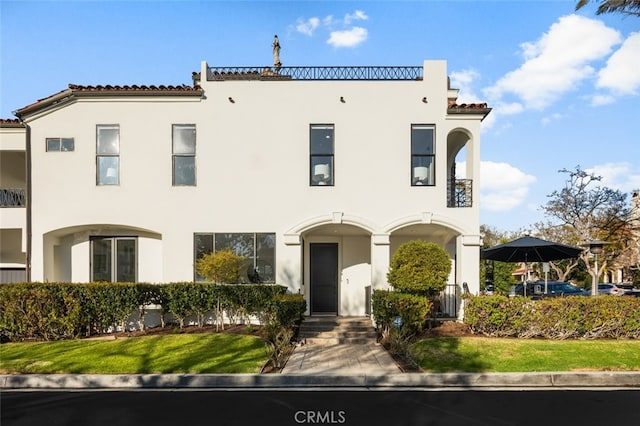 mediterranean / spanish house with stucco siding and a tiled roof