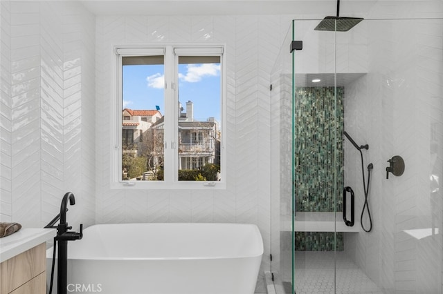 bathroom with a freestanding bath, tile walls, and a shower stall