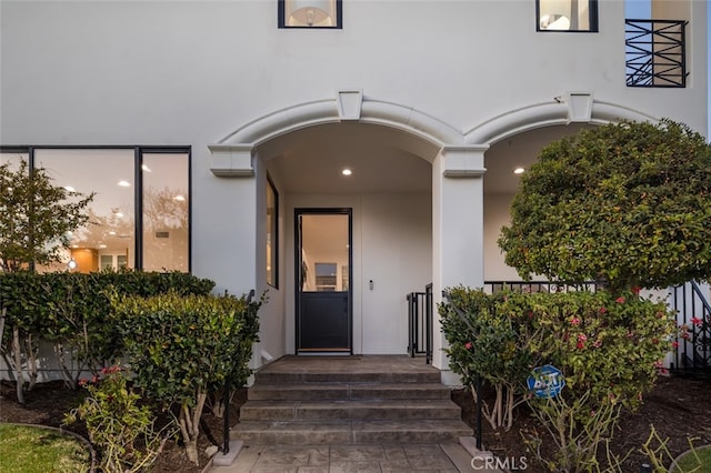 doorway to property featuring stucco siding