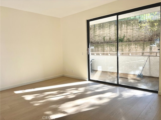 empty room with wood finished floors and baseboards