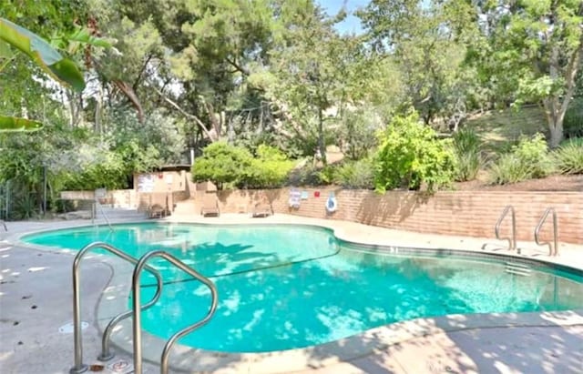 view of swimming pool featuring a patio, a fenced in pool, and fence