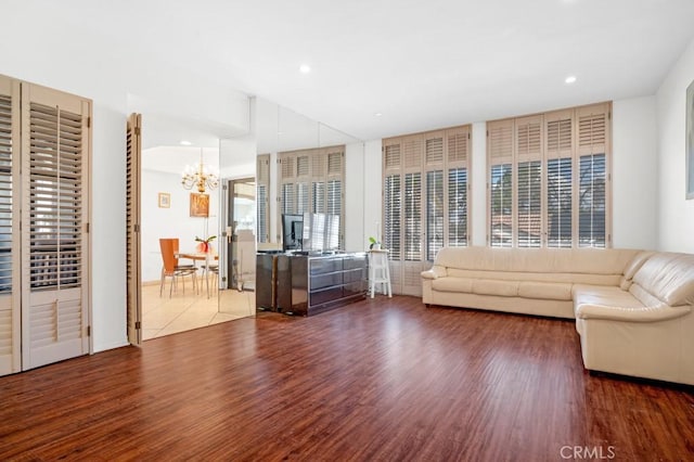 unfurnished living room featuring recessed lighting, a notable chandelier, and wood finished floors