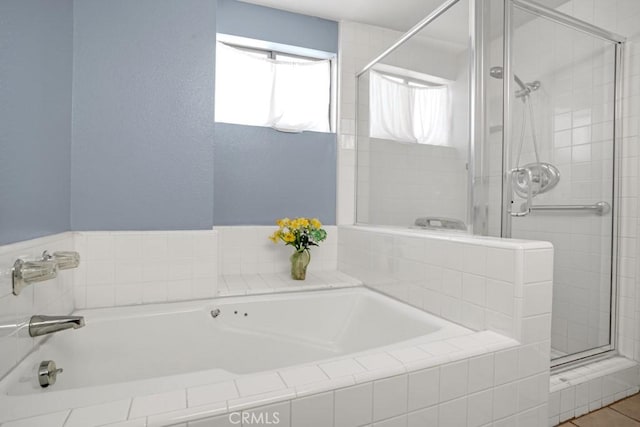 bathroom featuring a garden tub and a shower stall