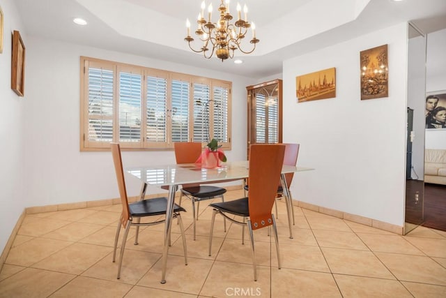 dining area featuring a tray ceiling, light tile patterned flooring, and a healthy amount of sunlight