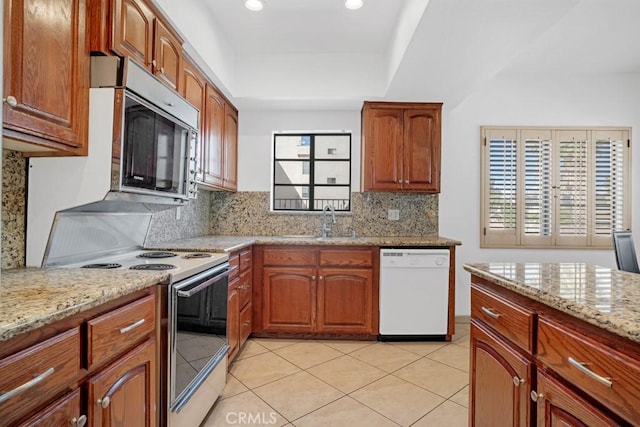 kitchen featuring tasteful backsplash, light stone countertops, dishwasher, electric range, and a sink