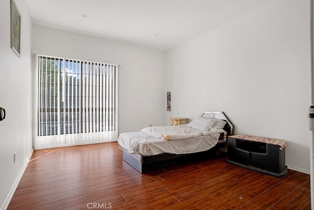 bedroom featuring baseboards and hardwood / wood-style flooring