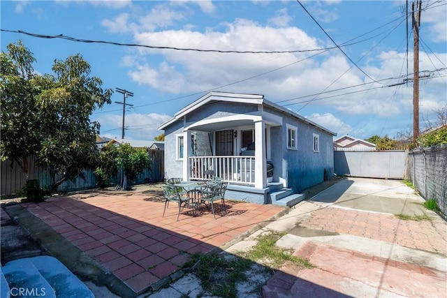 view of front facade with a patio area, a fenced backyard, and covered porch