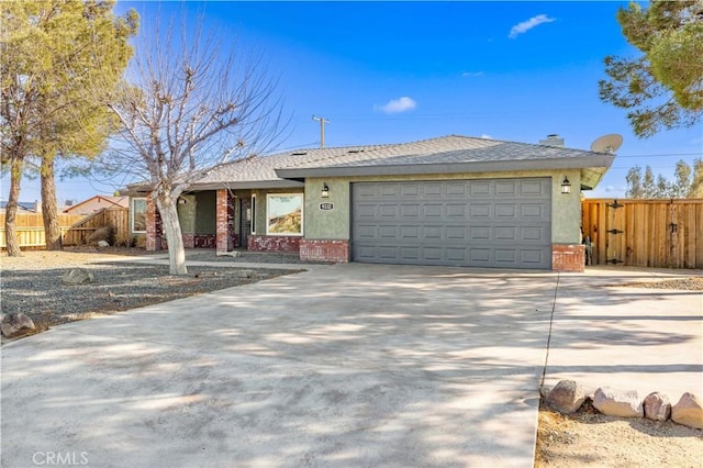 single story home with brick siding, concrete driveway, an attached garage, and fence