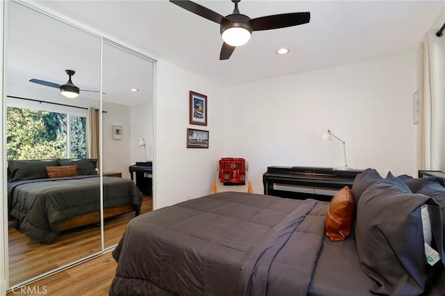 bedroom with a ceiling fan, recessed lighting, wood finished floors, and a closet