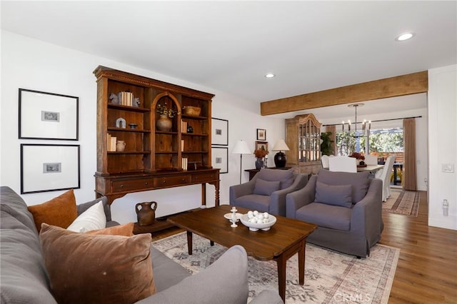 living room featuring an inviting chandelier, light wood-style flooring, recessed lighting, and beam ceiling