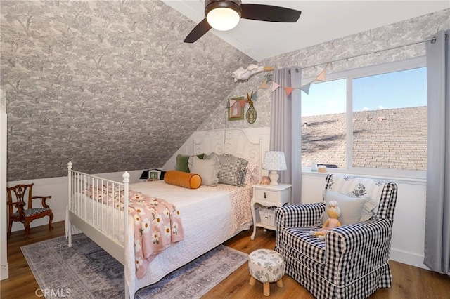 bedroom featuring a ceiling fan, lofted ceiling, and wood finished floors