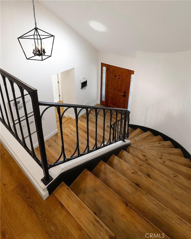 staircase with baseboards and wood finished floors