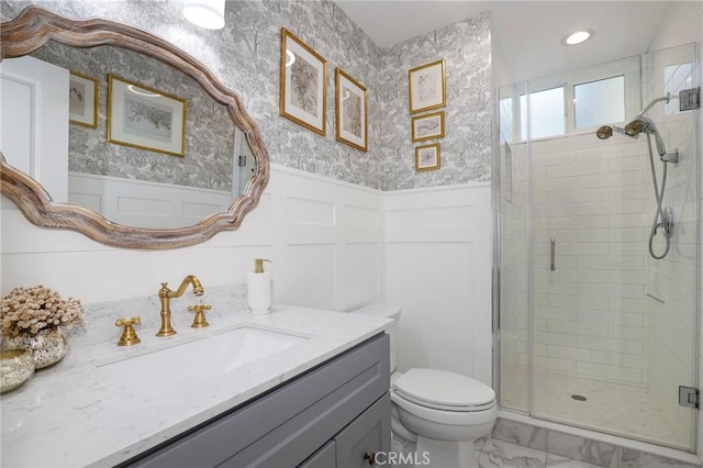 bathroom with wallpapered walls, a shower stall, marble finish floor, and wainscoting