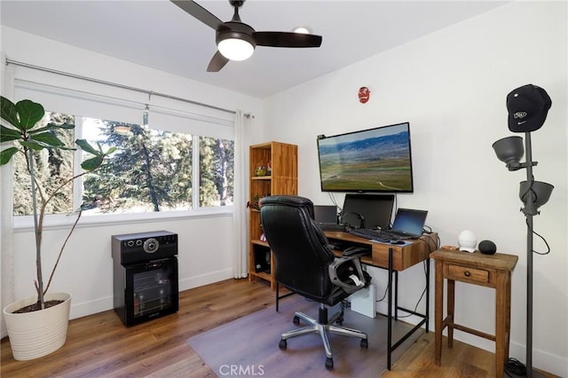 office space featuring a ceiling fan, wood finished floors, and baseboards