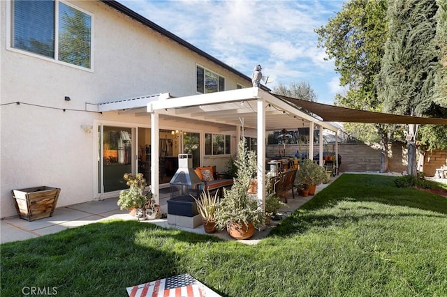 rear view of property featuring a patio area, a lawn, fence, and stucco siding