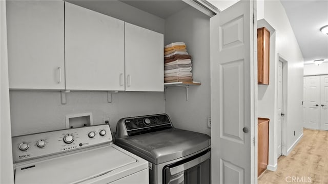 laundry room with separate washer and dryer, cabinet space, and light wood finished floors