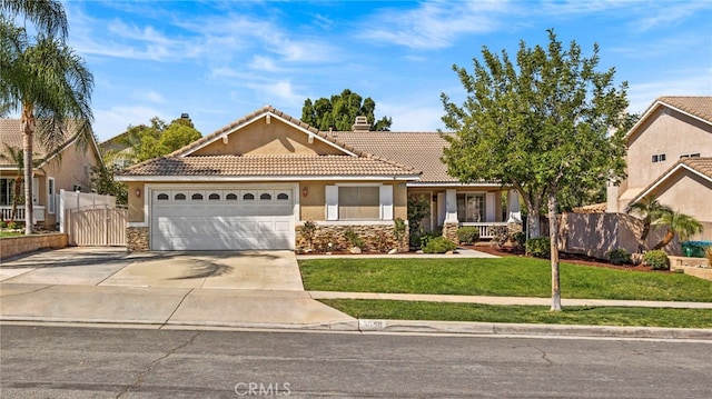 view of front of house featuring stucco siding, a front lawn, a gate, fence, and concrete driveway