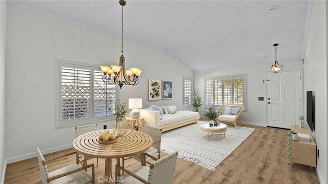 living room featuring vaulted ceiling, wood finished floors, baseboards, and a chandelier