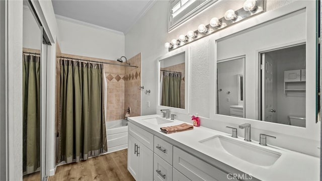 bathroom featuring crown molding, toilet, wood finished floors, and a sink