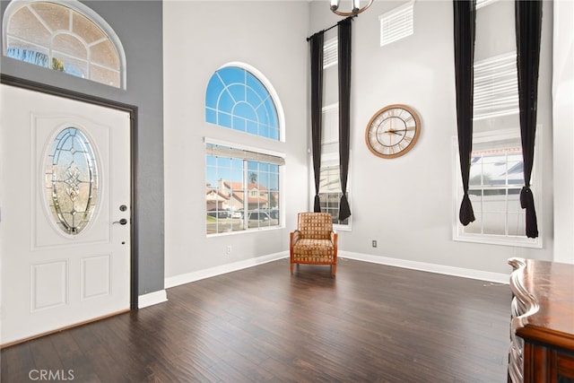 entryway featuring baseboards, a high ceiling, and wood finished floors