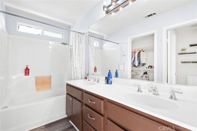 full bathroom with double vanity, visible vents, shower / tub combo with curtain, and a sink