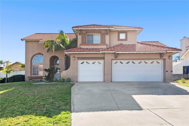 mediterranean / spanish house featuring fence, stucco siding, a front lawn, concrete driveway, and a tiled roof