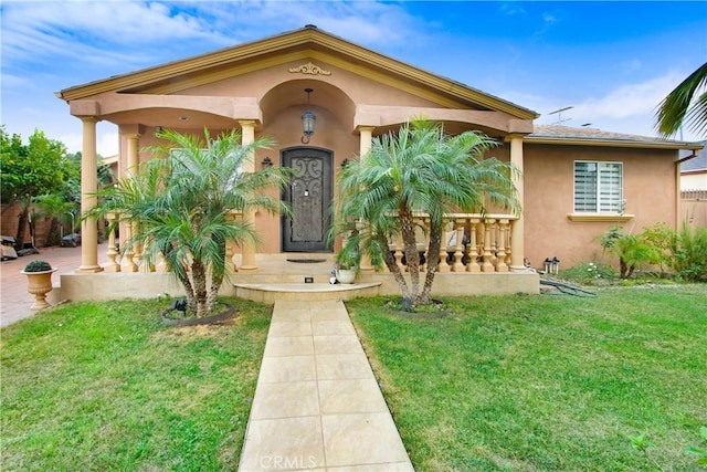 view of front facade with stucco siding and a front lawn