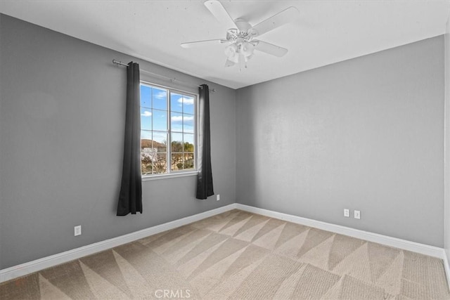 empty room with carpet flooring, ceiling fan, and baseboards