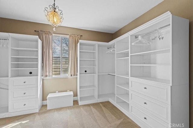 spacious closet with an inviting chandelier and carpet